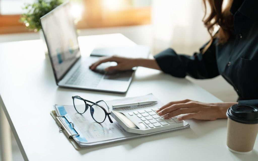 persona trabajando con portátil y calculadora